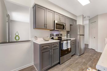 A kitchen with dark brown cabinets and stainless steel appliances.